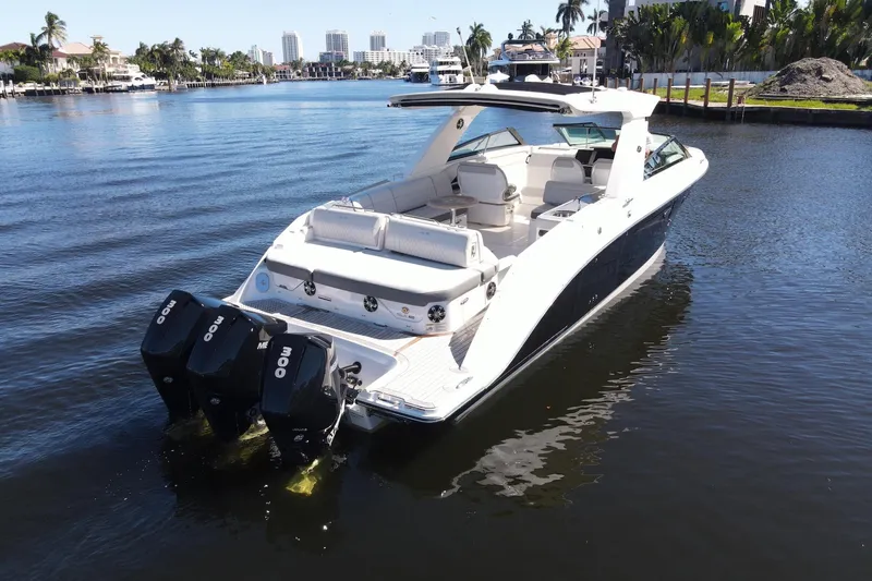 Slide: The Image of 2022 Sea Ray SLX 400 Outboard luxury boat on calm water, cityscape in background. - 2