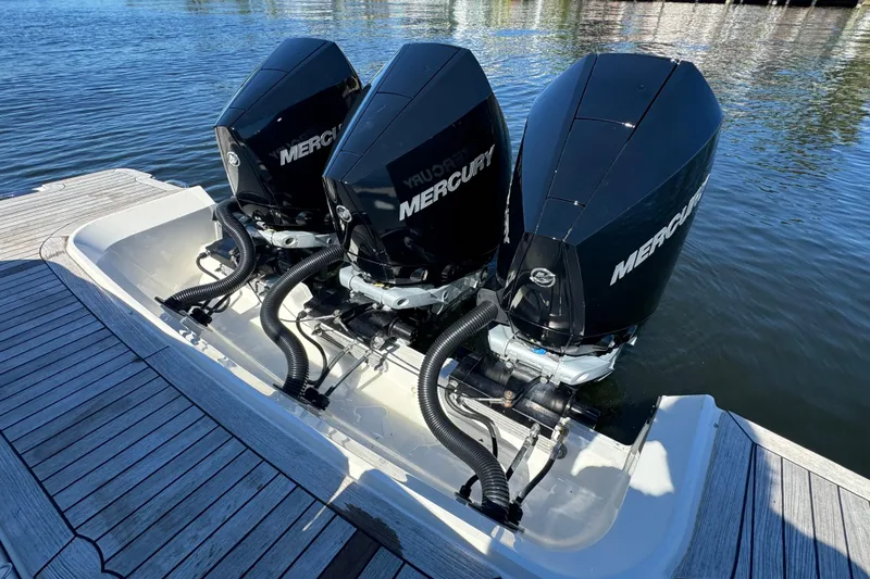 Slide: The Image of Triple Mercury outboard engines on 2022 Sea Ray SLX 400, docked on calm water. - 22