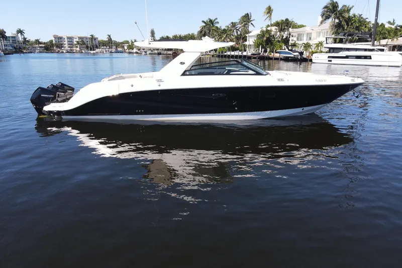 Slide: The Image of 2022 Sea Ray SLX 400 Outboard boat on calm water, surrounded by palm trees. - 3