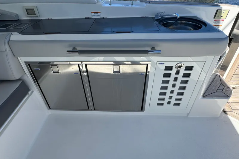 Slide: The Image of 2022 Sea Ray SLX 400 Outboard boat kitchen with stainless steel appliances and sink. - 35