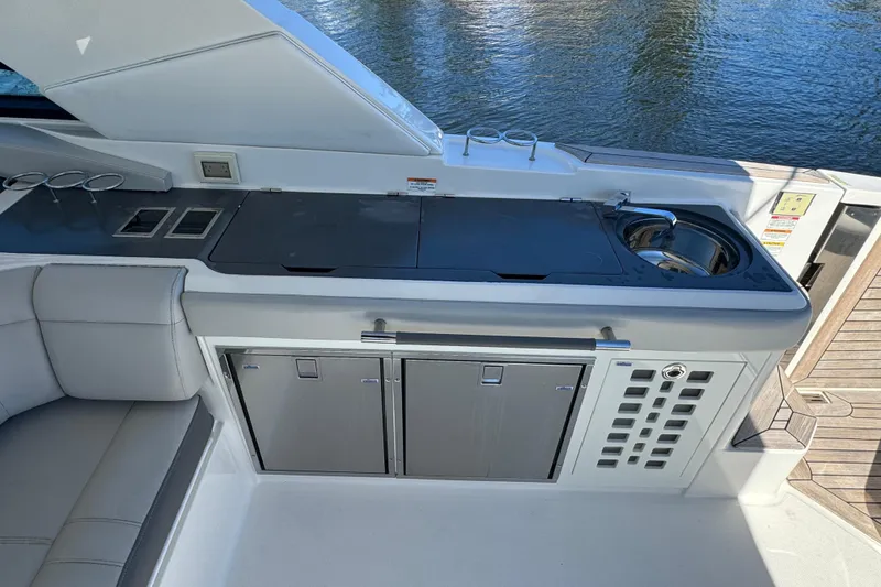 Slide: The Image of 2022 Sea Ray SLX 400 Outboard boat kitchen with sink and storage cabinets. - 36