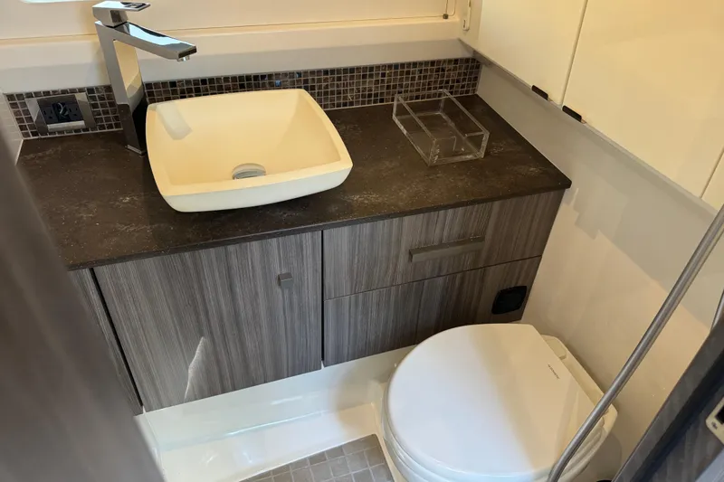 Slide: The Image of Modern bathroom in 2022 Sea Ray SLX 400 Outboard with sleek sink and toilet. - 72