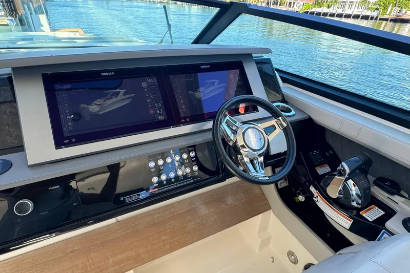 Slide: The Image of 2022 Sea Ray SLX 400 Outboard helm with dual Simrad displays and sleek steering wheel. - 8
