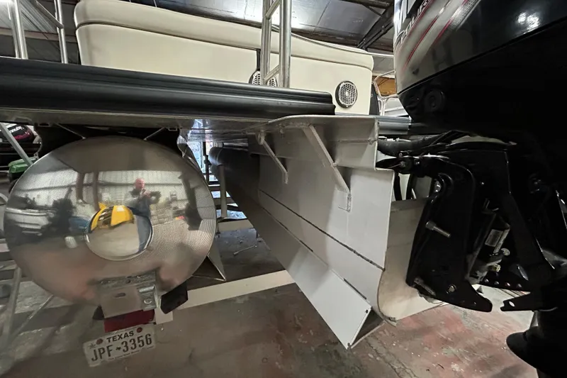 Slide: The Image of 2019 Harris CRUIZER 230 SALT EDITION pontoon boat interior with beige seating in a warehouse. - 25