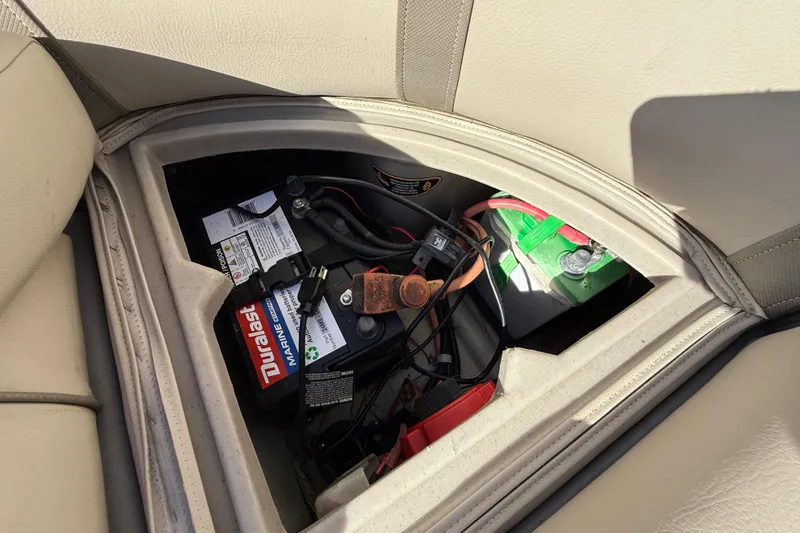 Slide: The Image of 2019 Harris CRUIZER 230 Salt Edition boat battery compartment with Duralast marine battery. - 82