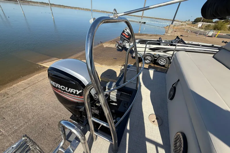 Slide: The Image of 2019 Harris CRUIZER 230 SALT EDITION with Mercury outboard motor at a lakeside dock. - 94