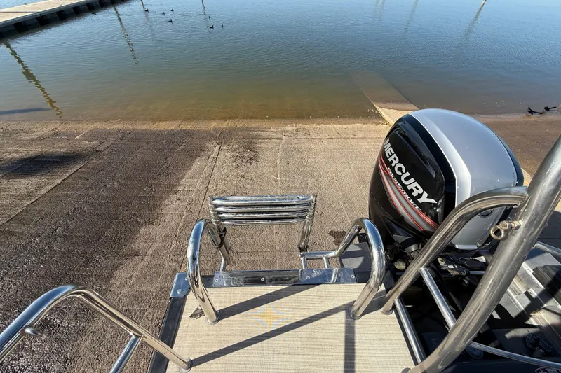 Slide: The Image of 2019 Harris CRUIZER 230 SALT EDITION boat with Mercury engine at a boat ramp. - 95