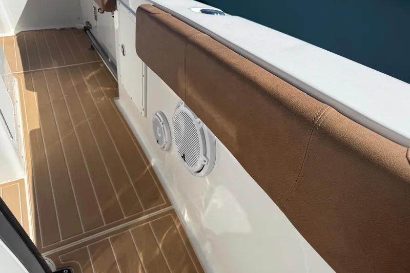 Slide: The Image of 2022 Sea Hunt Ultra 305 SE boat interior with brown cushioned seating and wood-patterned flooring. - 12