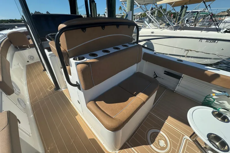 Slide: The Image of 2022 Sea Hunt Ultra 305 SE boat interior with tan seating and cup holders. - 16