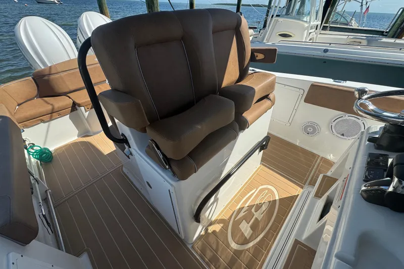 Slide: The Image of 2022 Sea Hunt Ultra 305 SE boat interior with brown seating and steering wheel. - 17