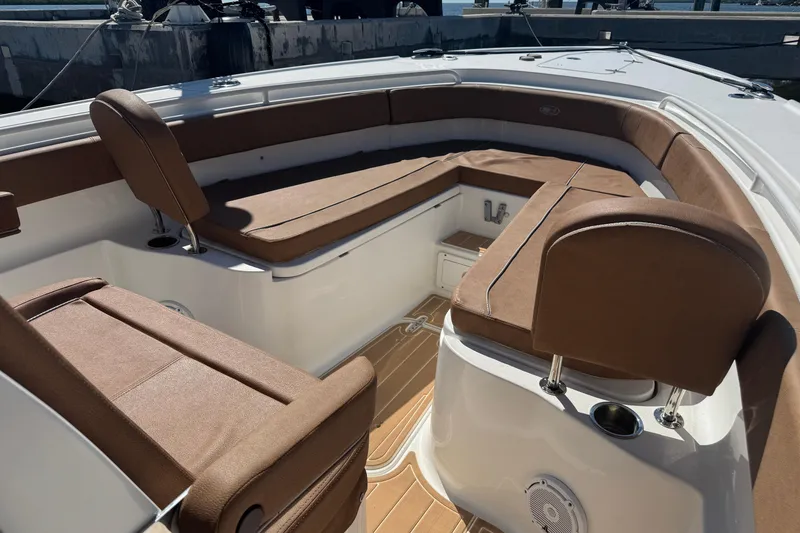 Slide: The Image of 2022 Sea Hunt Ultra 305 SE boat interior with brown cushioned seating and white deck. - 20
