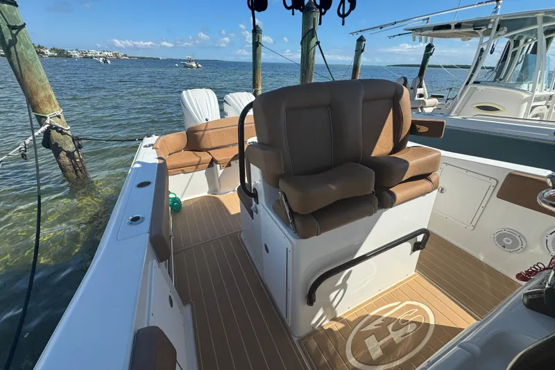 Slide: The Image of 2022 Sea Hunt Ultra 305 SE boat interior with brown seating and wood flooring. - 21