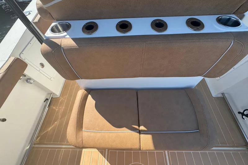 Slide: The Image of 2022 Sea Hunt Ultra 305 SE boat seating with cup holders and tan upholstery. - 22