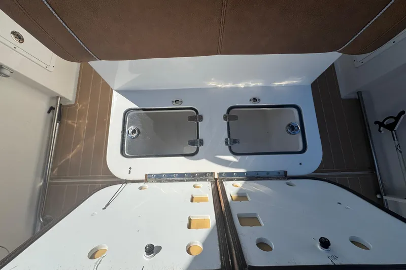 Slide: The Image of 2022 Sea Hunt Ultra 305 SE boat interior with storage compartments open. - 23