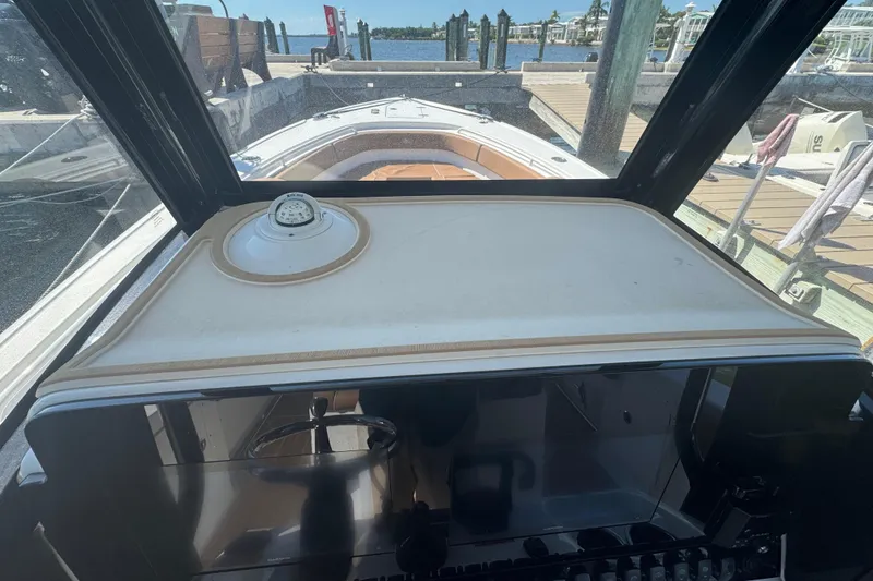 Slide: The Image of 2022 Sea Hunt Ultra 305 SE boat dashboard with compass, docked at marina. - 26