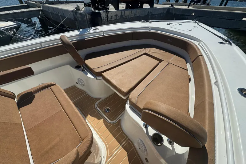 Slide: The Image of 2022 Sea Hunt Ultra 305 SE boat interior with brown cushioned seating. - 28