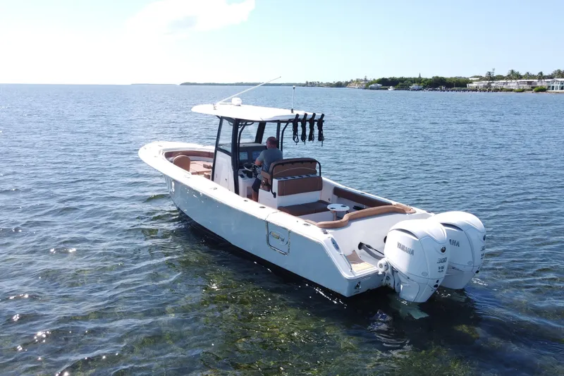 Slide: The Image of 2022 Sea Hunt Ultra 305 SE boat on calm water with dual Yamaha engines. - 3