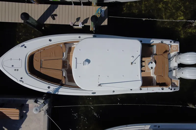 Slide: The Image of 2022 Sea Hunt Ultra 305 SE boat docked, aerial view, showcasing spacious deck and twin engines. - 30