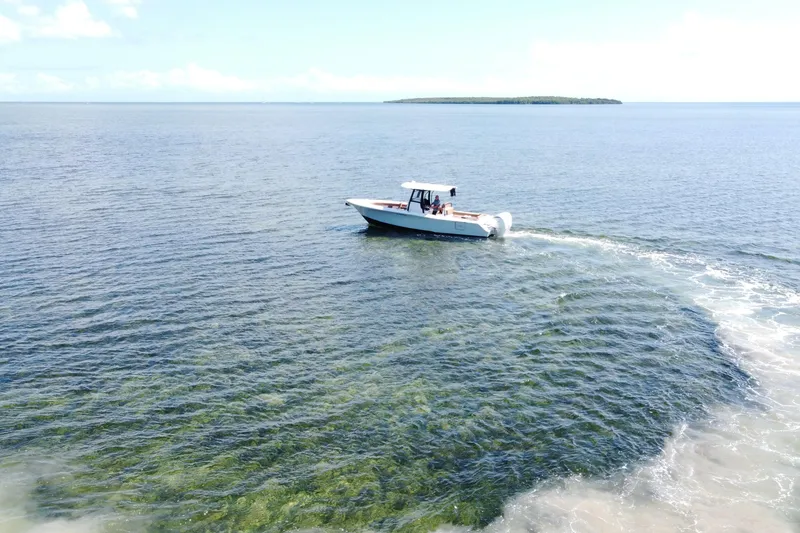 Slide: The Image of 2022 Sea Hunt Ultra 305 SE cruising on clear blue ocean waters. - 7