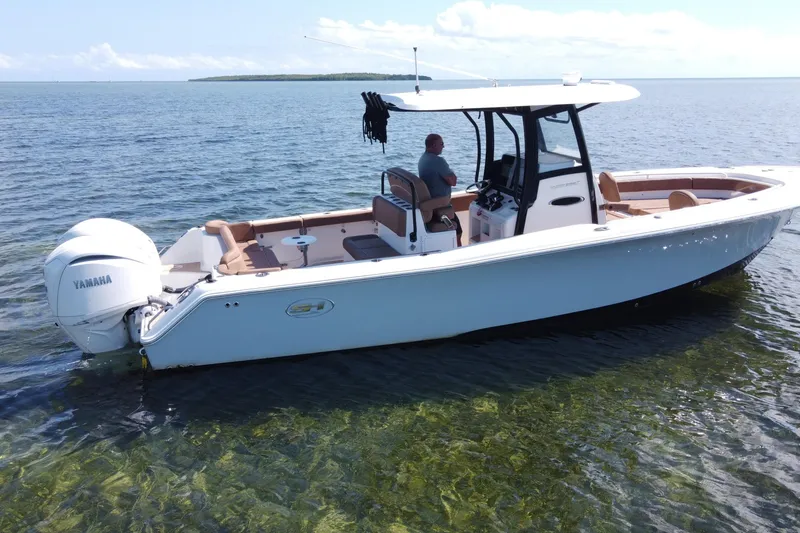 Slide: The Image of 2022 Sea Hunt Ultra 305 SE boat on calm water with Yamaha engine. - 8