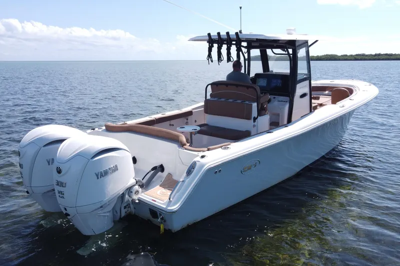 Slide: The Image of 2022 Sea Hunt Ultra 305 SE boat with dual Yamaha engines on calm water. - 9