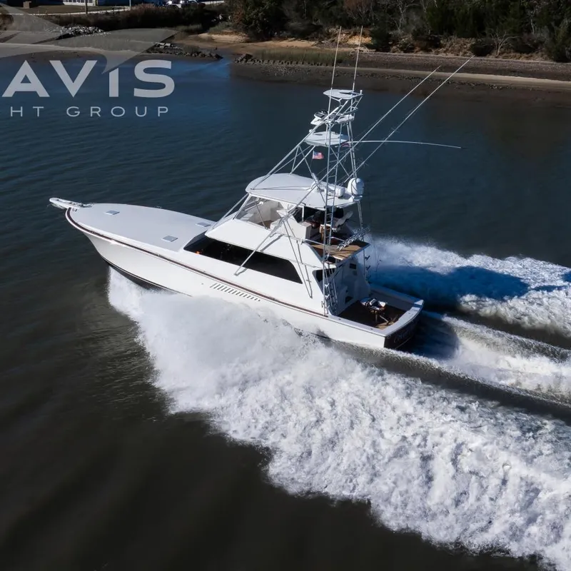 The Image of 1998 Viking 58 Convertible yacht cruising on a ICM in Cape May, surrounded by lush greenery. - 0