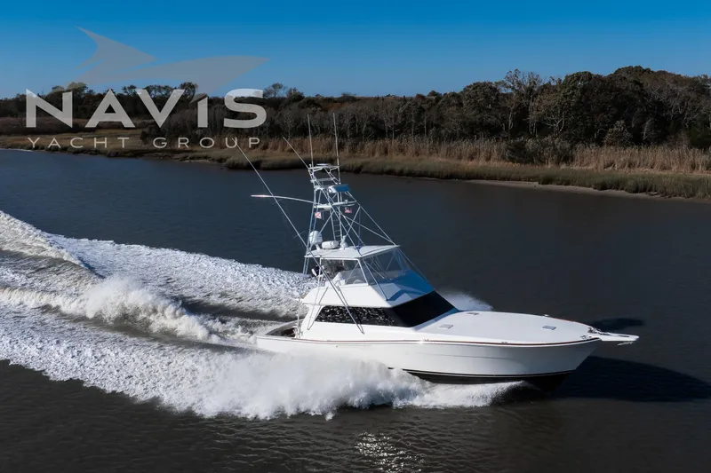 Slide: The Image of 1998 Viking 58 Convertible yacht cruising on a calm river, surrounded by lush trees. - 12