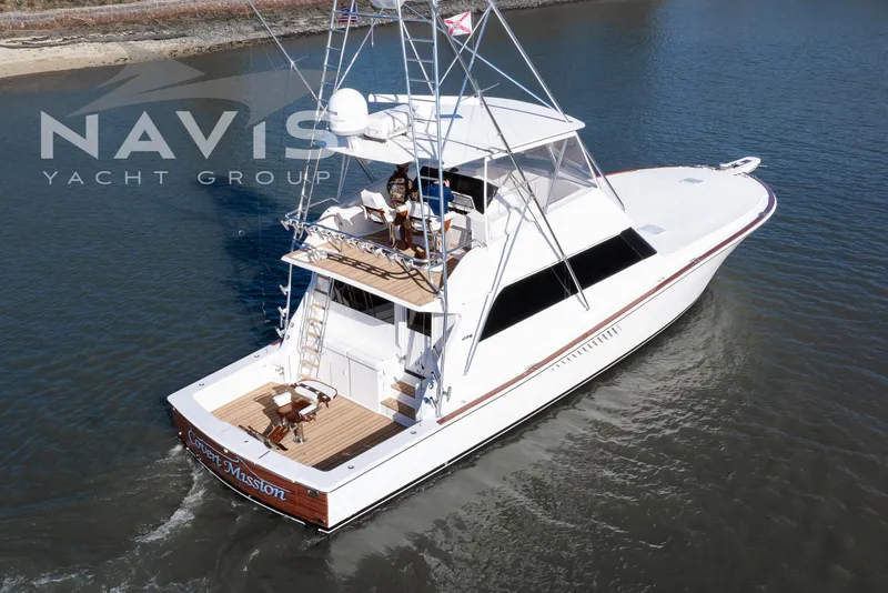 Slide: The Image of 1998 Viking 58 Convertible yacht deck with fishing chair and ladder, under clear blue sky. - 17