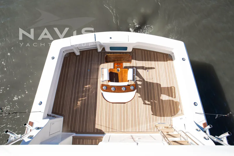 Slide: The Image of 1998 Viking 58 Convertible yacht deck with wooden flooring and fishing chair. - 18