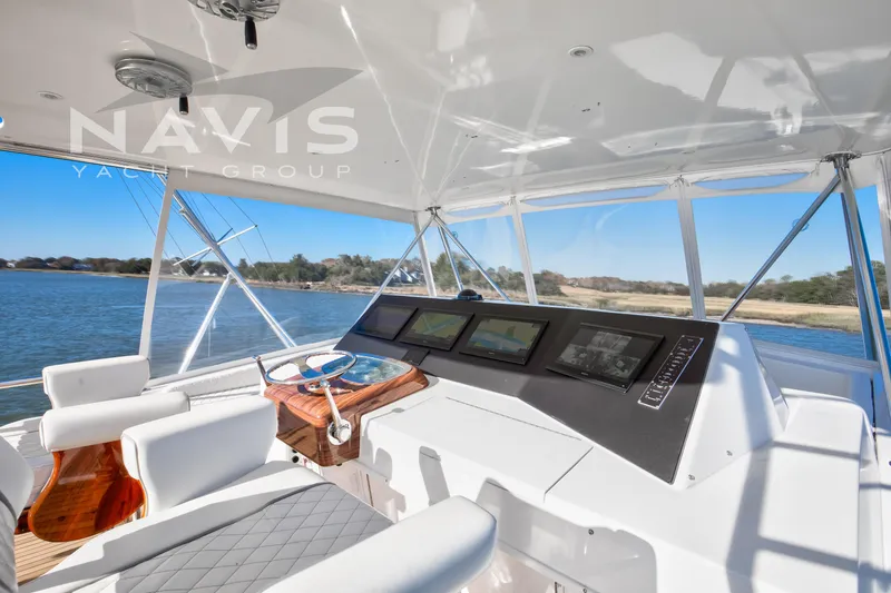 Slide: The Image of Interior view of 1998 Viking 58 Convertible yacht with elegant seating and scenic waterway. - 32