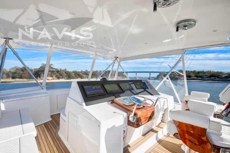 Slide: The Image of Luxurious 1998 Viking 58 Convertible yacht interior with helm and seating, overlooking serene waters. - 34