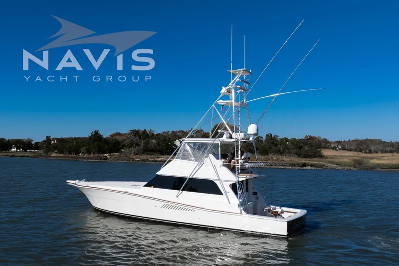 Slide: The Image of 1998 Viking 58 Convertible yacht cruising ICW, surrounded by lush greenery. - 4