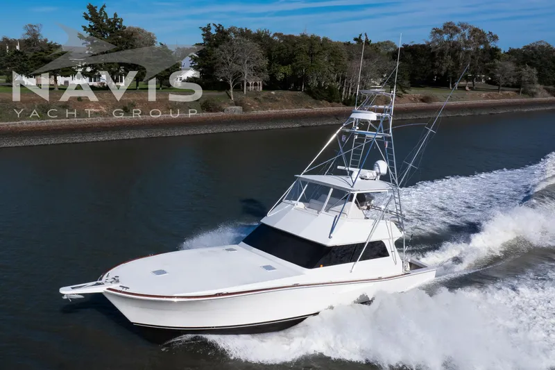 Slide: The Image of 1998 Viking 58 Convertible yacht cruising on a river, Navis Yacht Group logo visible. - 5