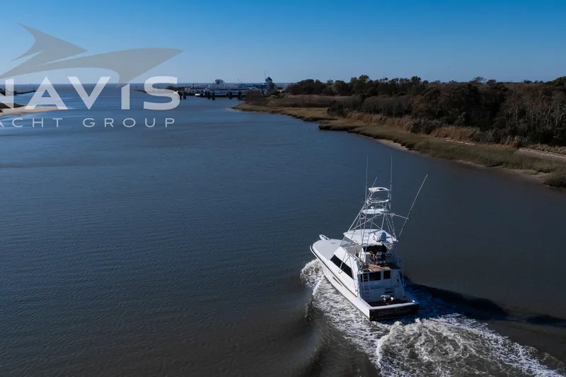 Slide: The Image of 1998 Viking 58 Convertible yacht cruising on a river, Navis Yacht Group logo visible. - 8