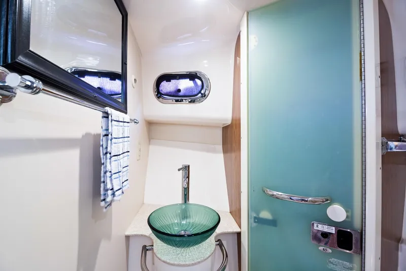 Slide: The Image of 2013 Pursuit OS 345 Offshore bathroom with glass sink and frosted shower door. - 12