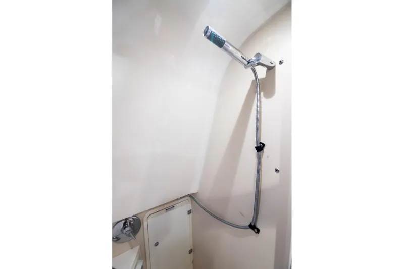 Slide: The Image of Shower area in 2013 Pursuit OS 345 Offshore boat, featuring a handheld showerhead. - 13