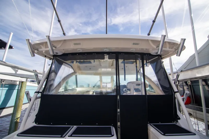 Slide: The Image of 2013 Pursuit OS 345 Offshore boat with covered cockpit and fishing rod holders. - 19