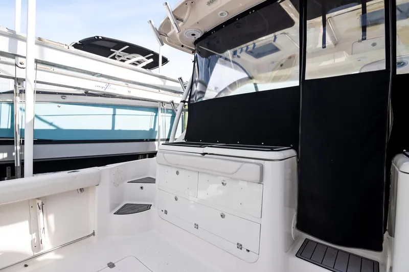 Slide: The Image of 2013 Pursuit OS 345 Offshore boat interior with storage compartments and seating area. - 20