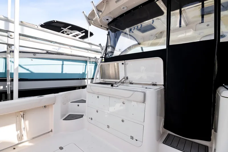 Slide: The Image of 2013 Pursuit OS 345 Offshore boat interior with storage and sink. - 22