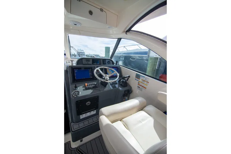 Slide: The Image of 2013 Pursuit OS 345 Offshore boat helm with steering wheel and navigation system. - 27