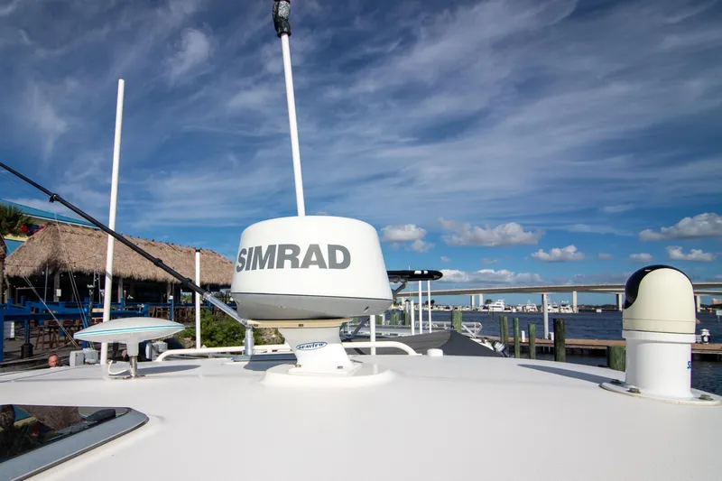 Slide: The Image of 2013 Pursuit OS 345 Offshore boat with Simrad radar, docked under a clear blue sky. - 33