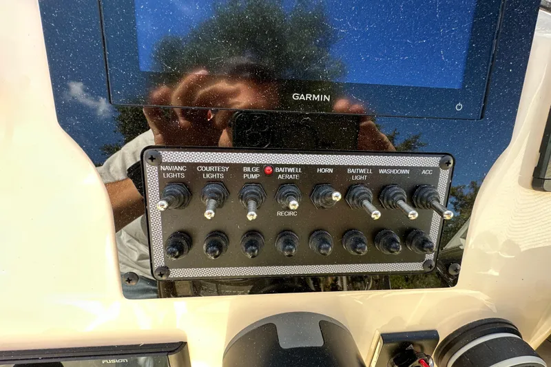 Slide: The Image of Control panel of 2025 Scout 195 Sport Dorado boat with various switches and Garmin display. - 11