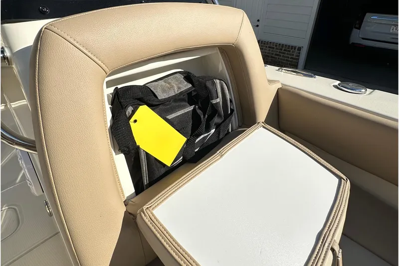 Slide: The Image of 2025 Scout 195 Sport Dorado boat seat storage with bag and yellow tag. - 21