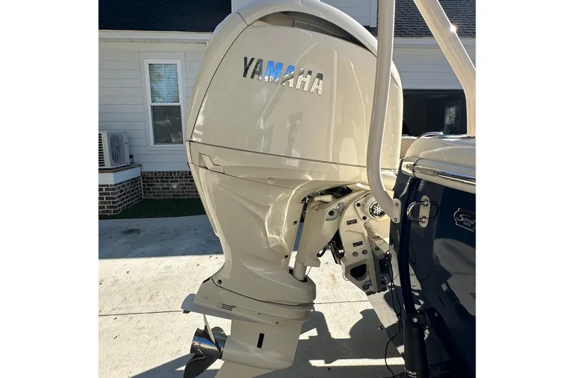 Slide: The Image of 2025 Scout 195 Sport Dorado with Yamaha outboard motor, parked in driveway. - 3