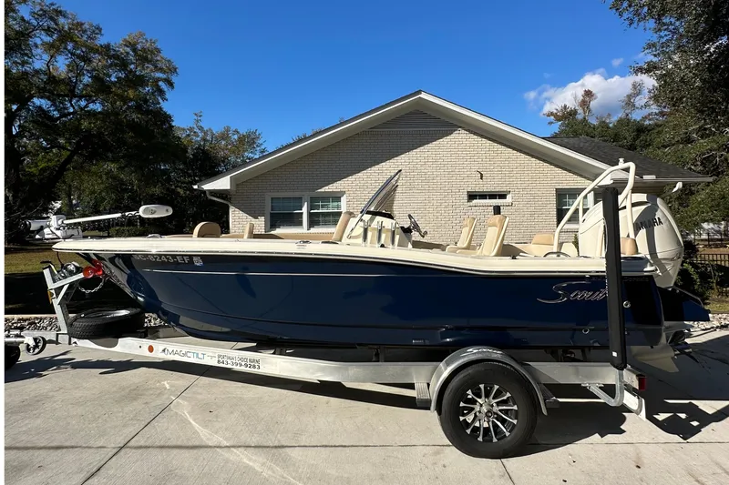 Slide: The Image of 2025 Scout 195 Sport Dorado boat on trailer, parked in front of a house. - 9