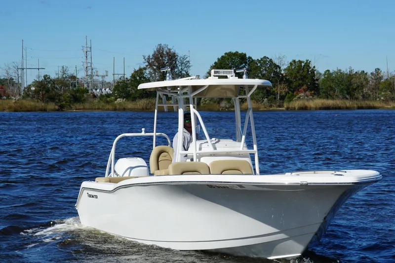 Slide: The Image of 2015 Tidewater 230 LXF boat cruising on a calm river under clear blue skies. - 3