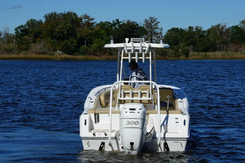 Slide: The Image of 2015 Tidewater 230 LXF boat cruising on a serene lake with lush forest backdrop. - 4