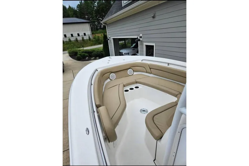 Slide: The Image of 2015 Tidewater 230 LXF boat with tan seating, parked near a house. - 6