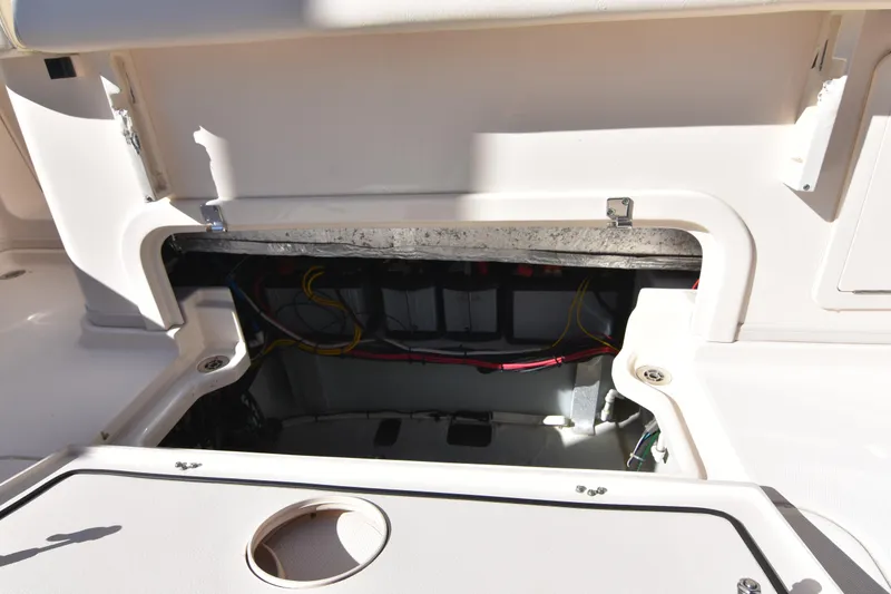 Slide: The Image of 2017 Grady-White Express 330 boat storage compartment with visible wiring and battery setup. - 19