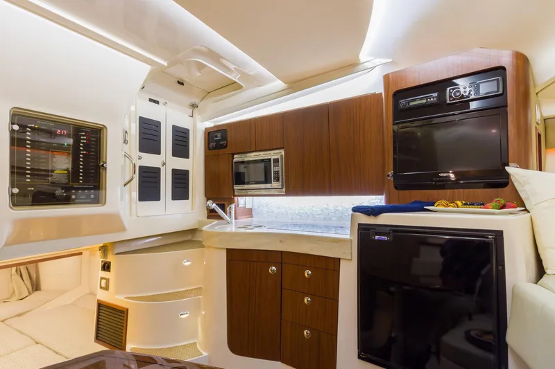 Slide: The Image of Manufacturer Provided Image: 2017 Grady-White Express 330 interior kitchen with modern appliances and wood cabinetry. - 27
